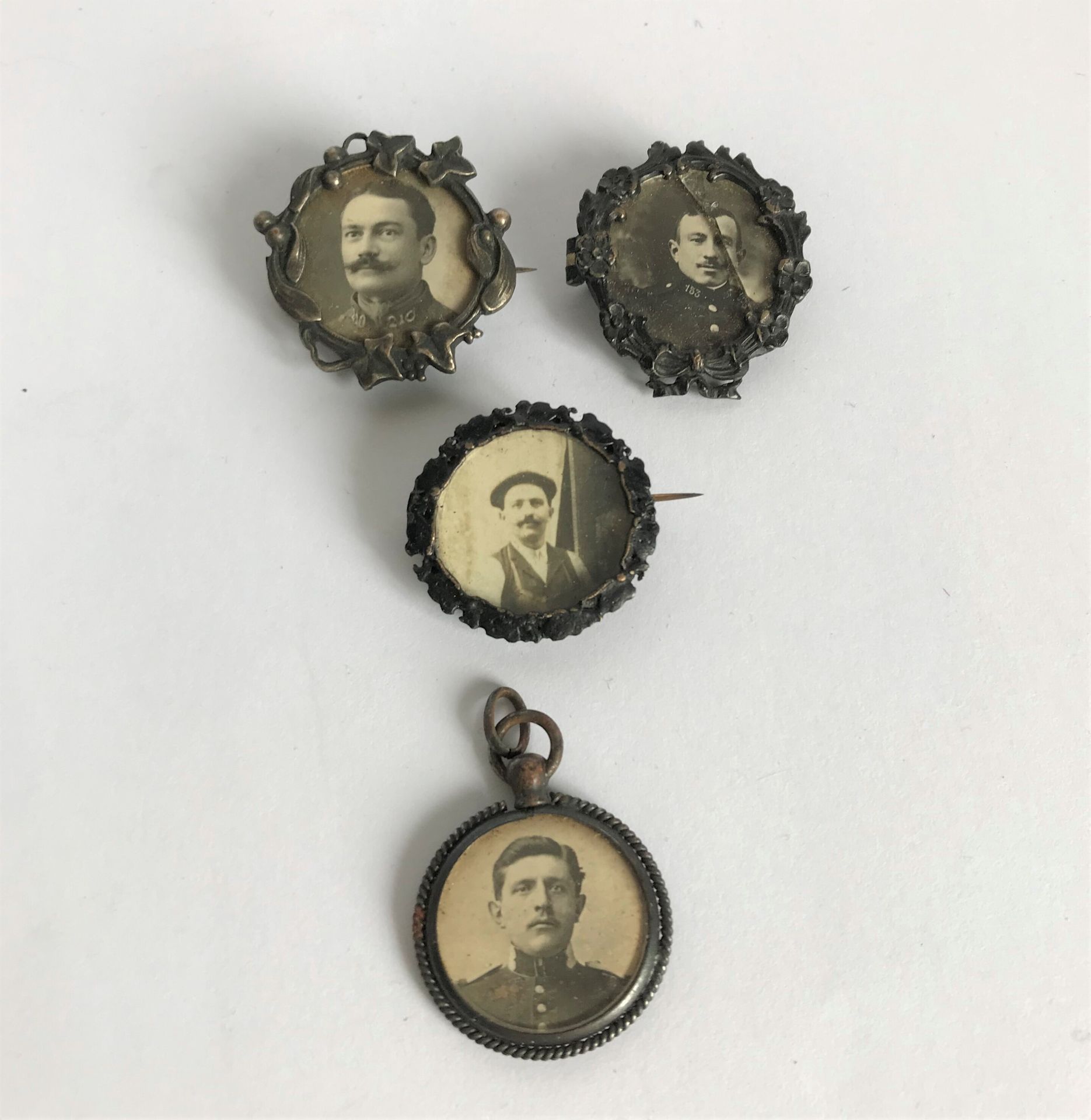 Null 一套四枚带有士兵照片的凿刻金属奖章或吊坠。

D.2.5厘米

一个破碎的玻璃