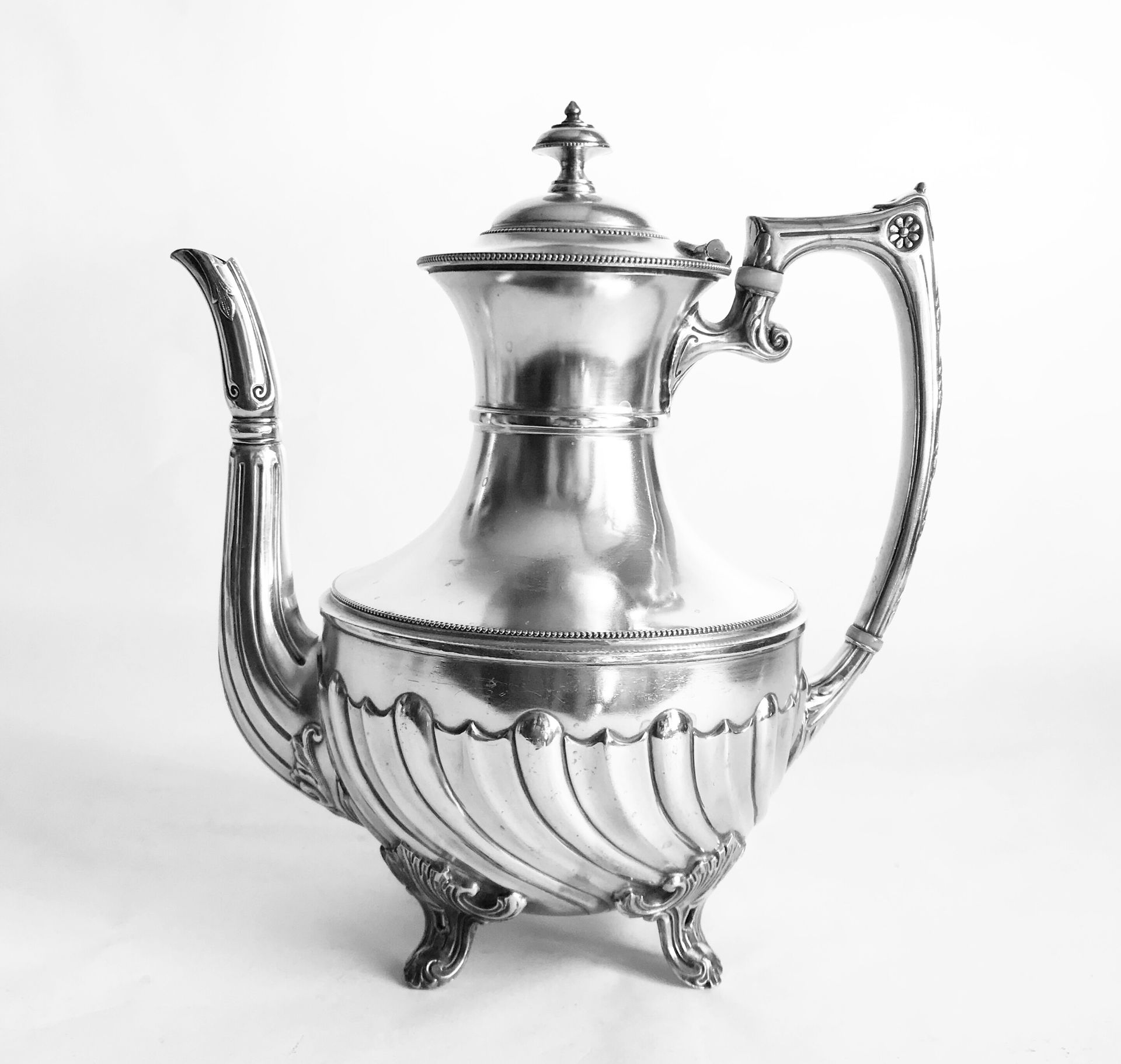 Null 镀银茶壶，壶身铸有帘子。它用四只脚站立。英国作品，20世纪初

H.25厘米