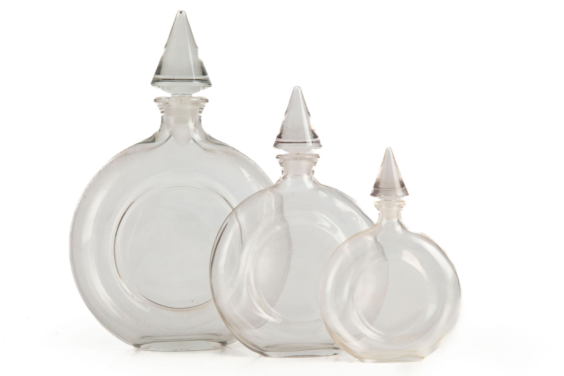 Null GUERLAIN 

Suite of three glass bottles of round form, the stopper in the s&hellip;
