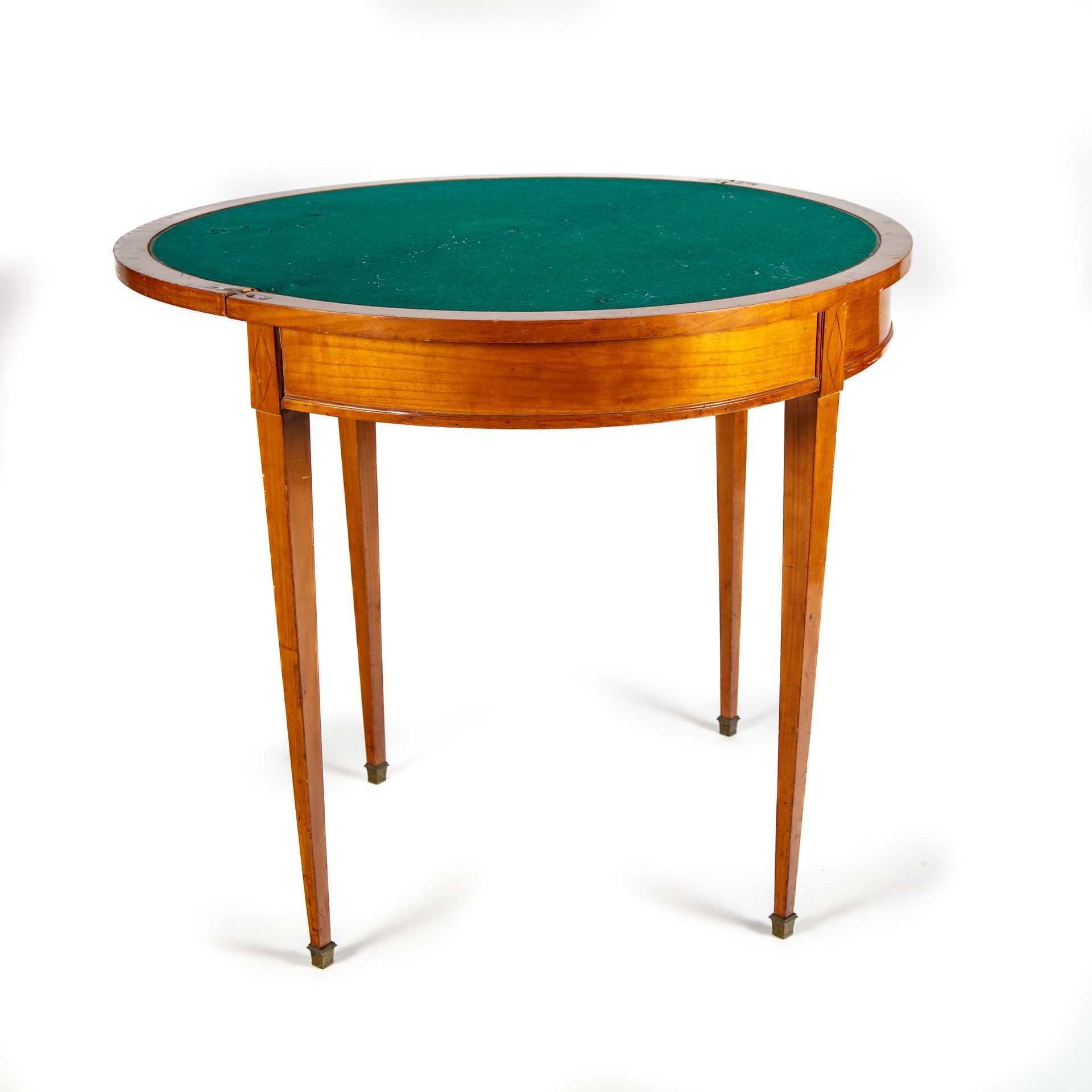 Null 半月形的游戏桌，直腿，由果木单板制成，有一个折叠的顶部。 
路易十六风格 
H.75厘米；宽85厘米；长42厘米