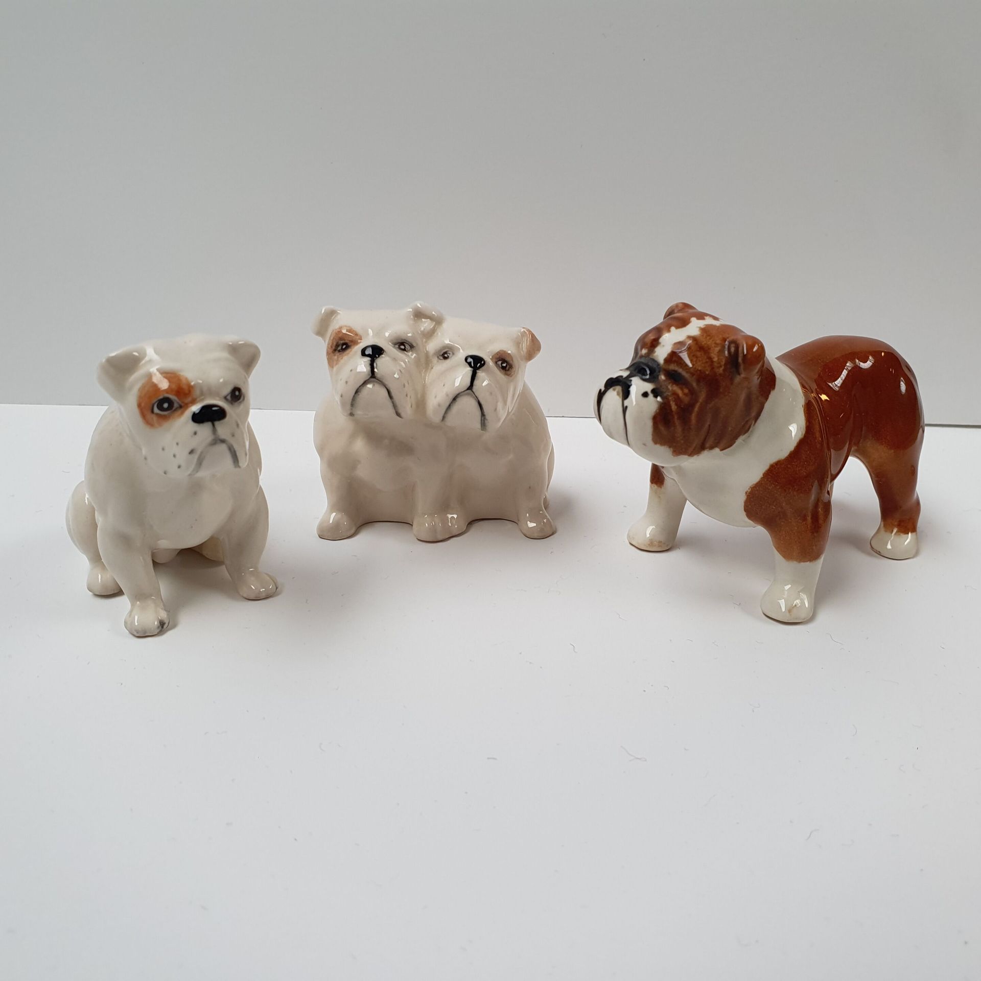 Null 制造：约翰-贝斯维克 - 英国 
一套三件珐琅彩瓷器，代表斗牛犬
背面有签名 
H.5,5厘米和6厘米