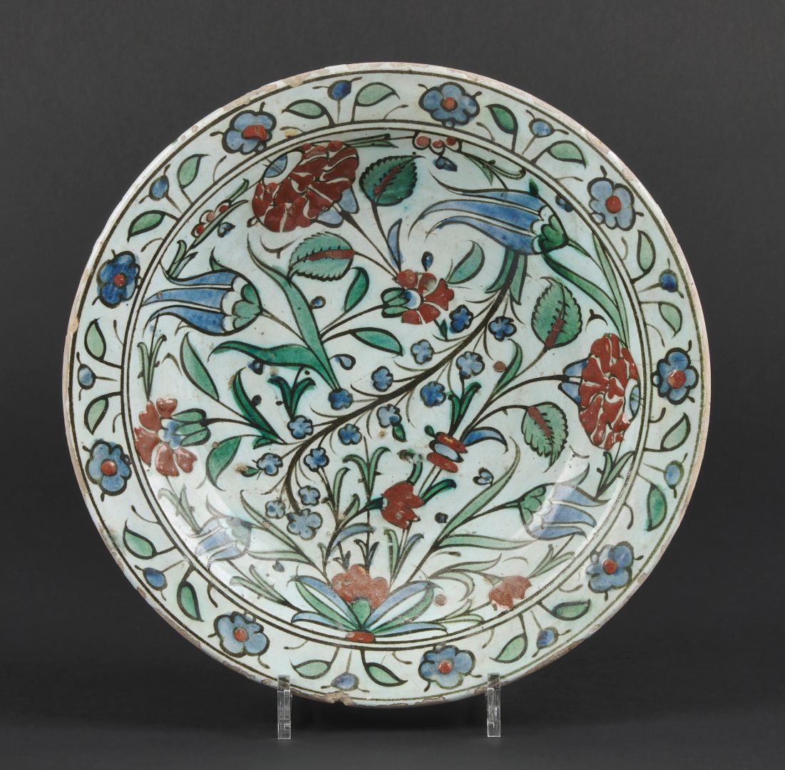Null Iznik圆形硅质陶瓷盘，有郁金香和康乃馨的多色装饰。17世纪初。D. 31厘米。一发而不可收拾。