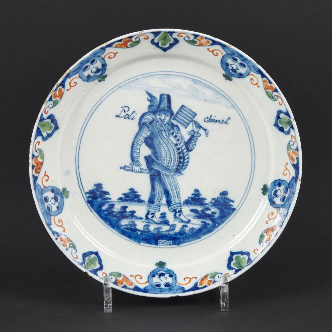 Null Delft Earthenware盘子，中间有蓝色单色装饰的Polichinel，标题和编号为35，翅膀上有蓝色、红色和绿色的叶子装饰。18世纪。 D&hellip;