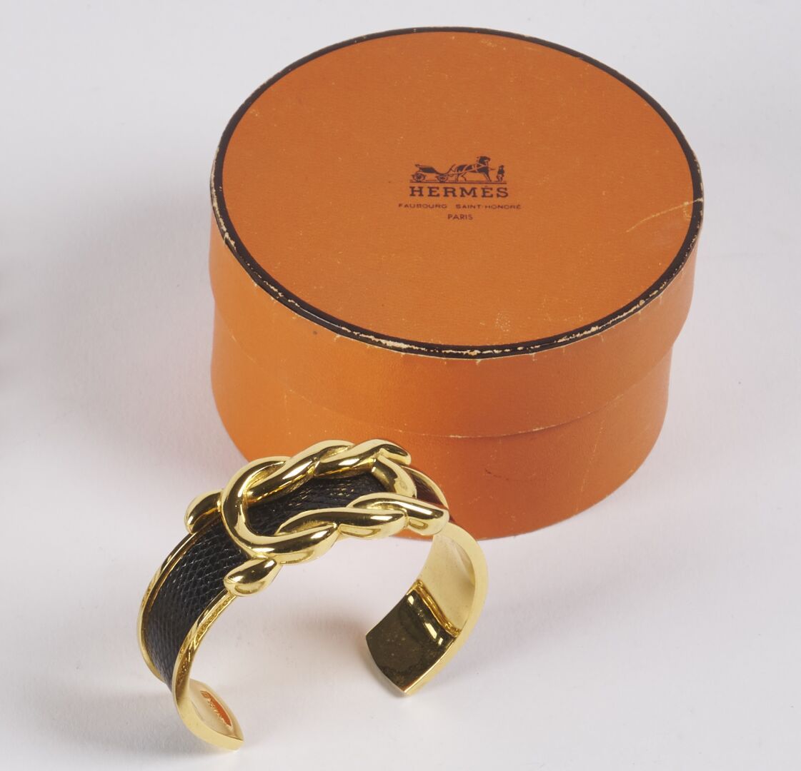 Null HERMES 

Bracelet jonc ouvrant en métal doré agrémenté de cuir grainé, et d&hellip;