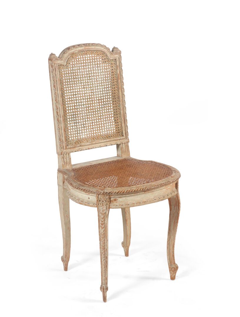 Null 一把雕刻和涂漆的木椅，有一个藤条背和座位，靠在弯曲的腿上。

路易十六时期

高86厘米；长43厘米