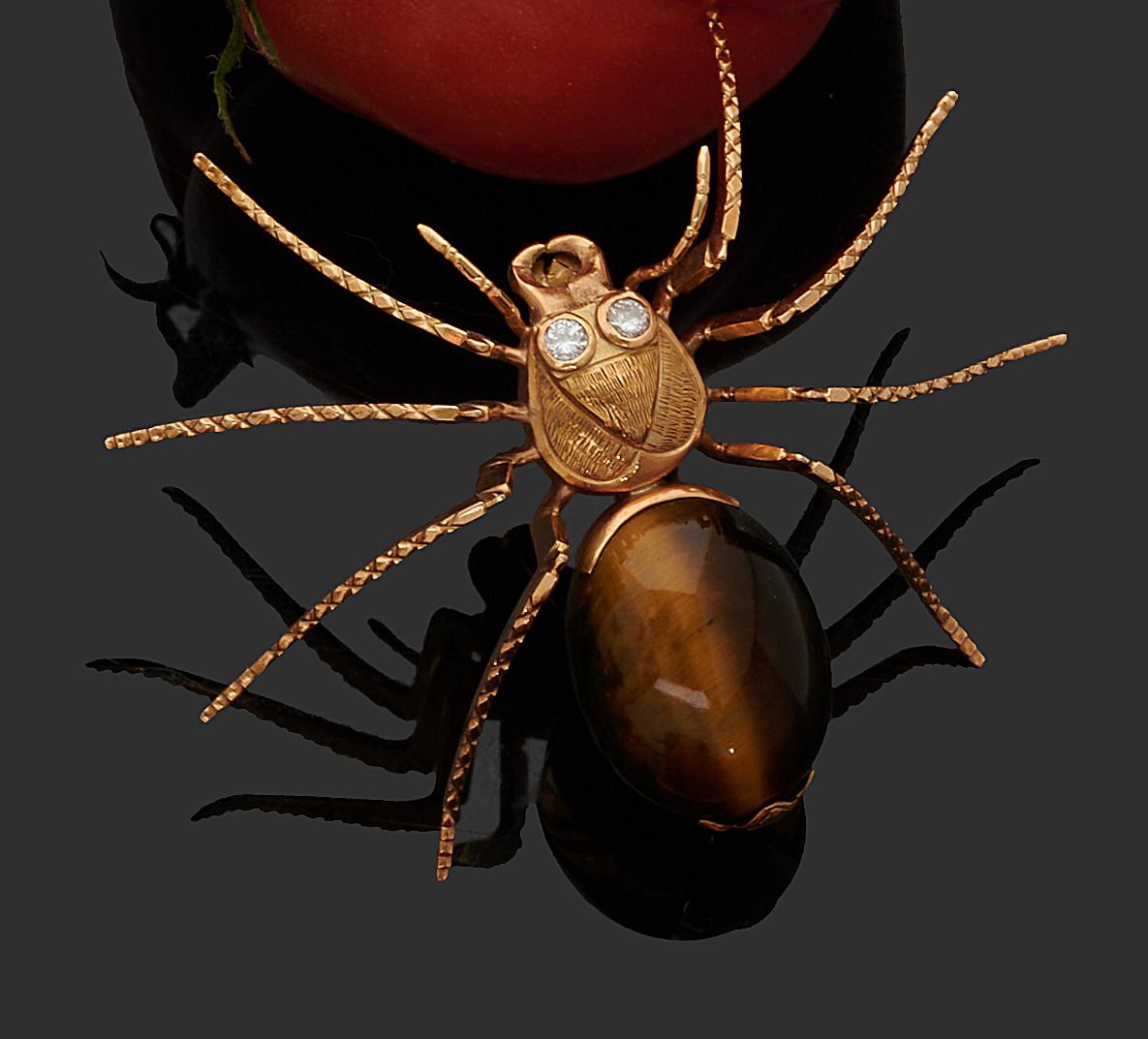 Null 黄金胸针750千分之一，代表一只蜘蛛，身体装饰着凸圆形的石英虎眼，眼睛装饰着明亮的圆形钻石。
高度：4厘米
宽度 : 6,2 cm
毛重 : 19,5&hellip;