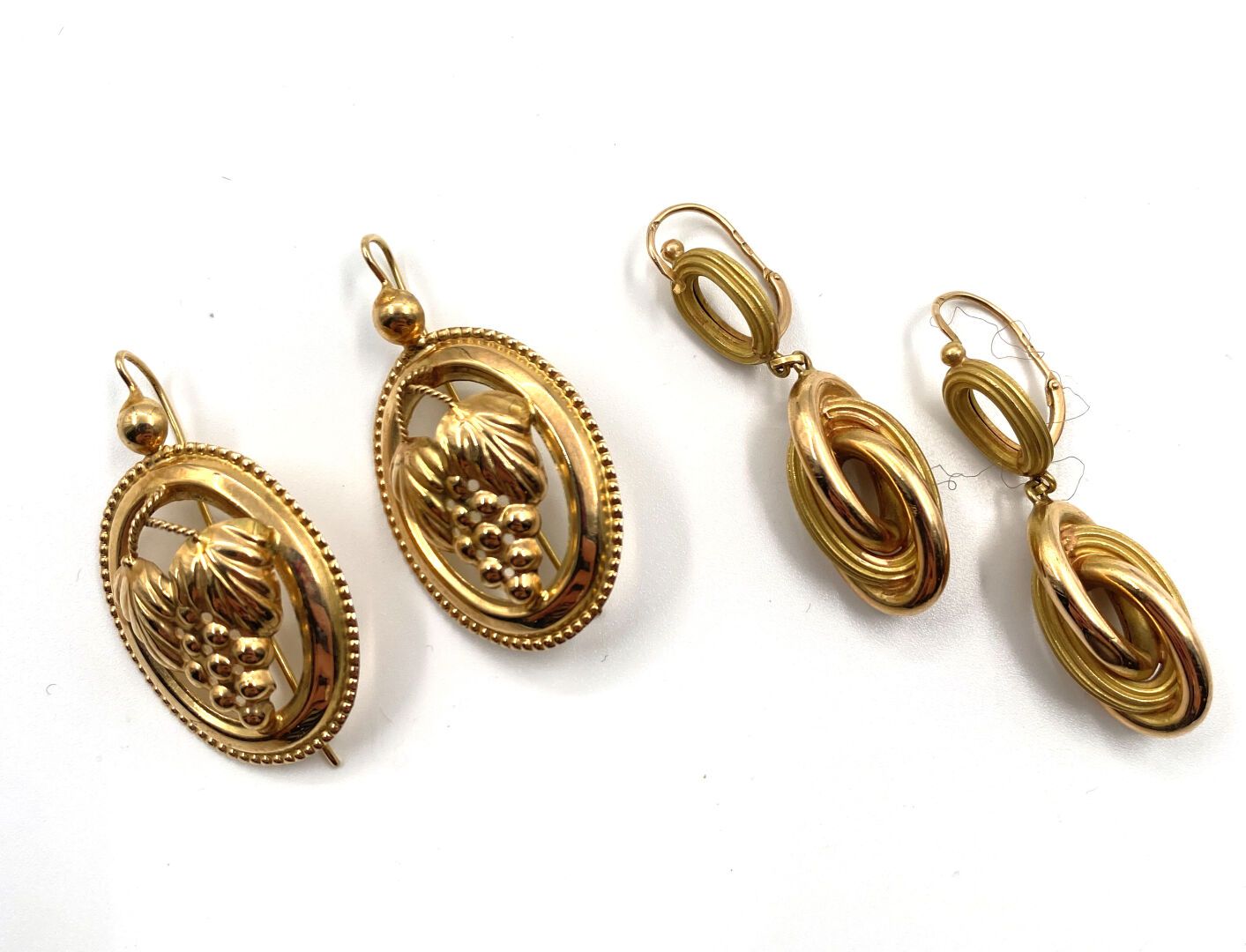 Null 两对千分之七十五的黄金耳环，一只饰有潘帕斯，另一只饰有交错的戒指。
(老板们)。
用于穿耳的系统。
高度 : 3,7 cm
总毛重 : 8,2 g