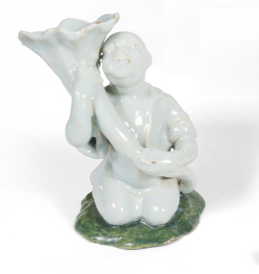 Null 布鲁塞尔
陶器雕像，代表一个跪着的中国人，拿着一个角，在一个绿色的底座上。
18世纪。 
H.12,5厘米。