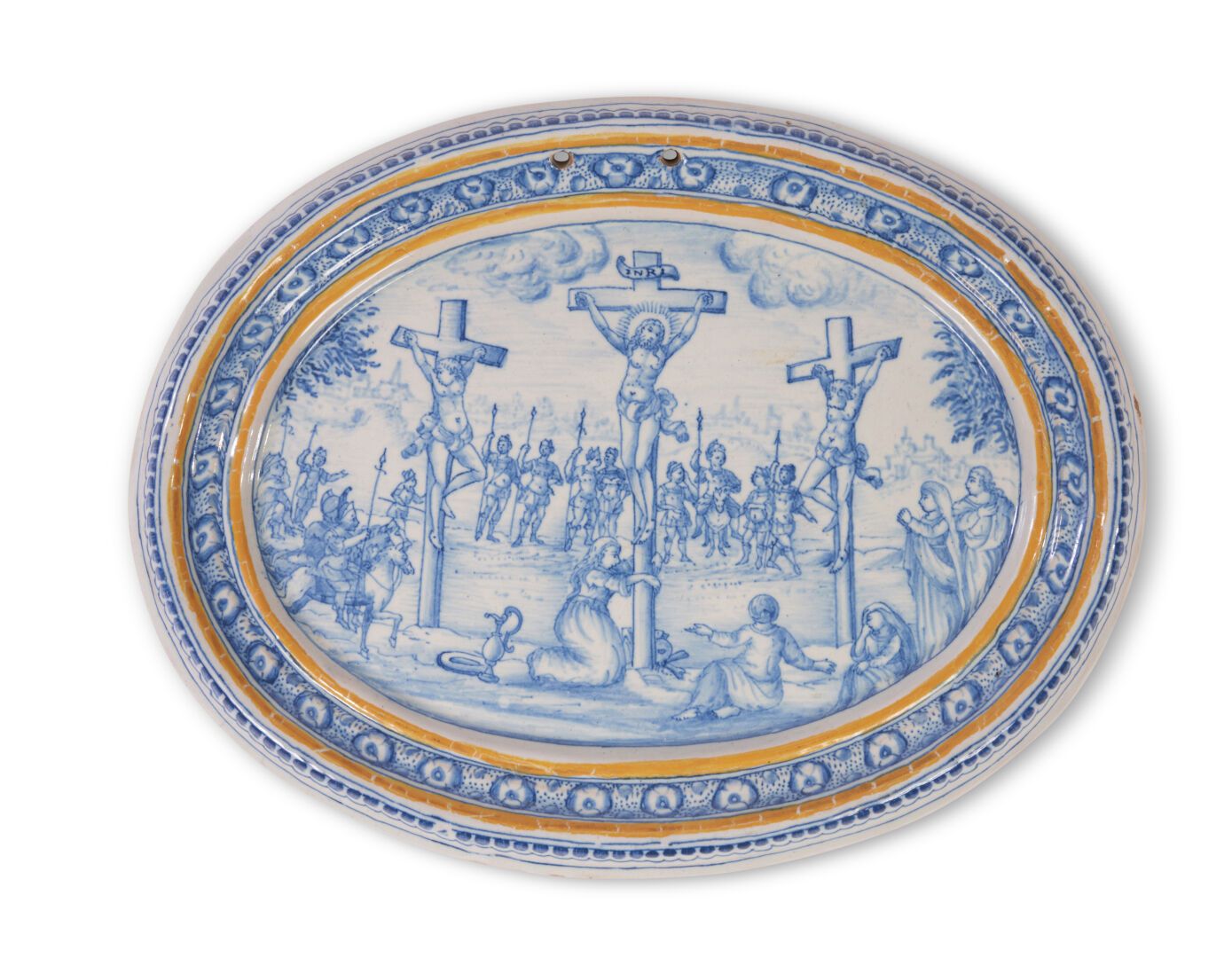 Null 蒙彼利埃
椭圆形陶盘，中间有蓝色单色装饰的耶稣受难场景，黄色圆角和花纹边。
18世纪。 
L. 24,5 cm x 18 cm.
边缘有一个小缺口