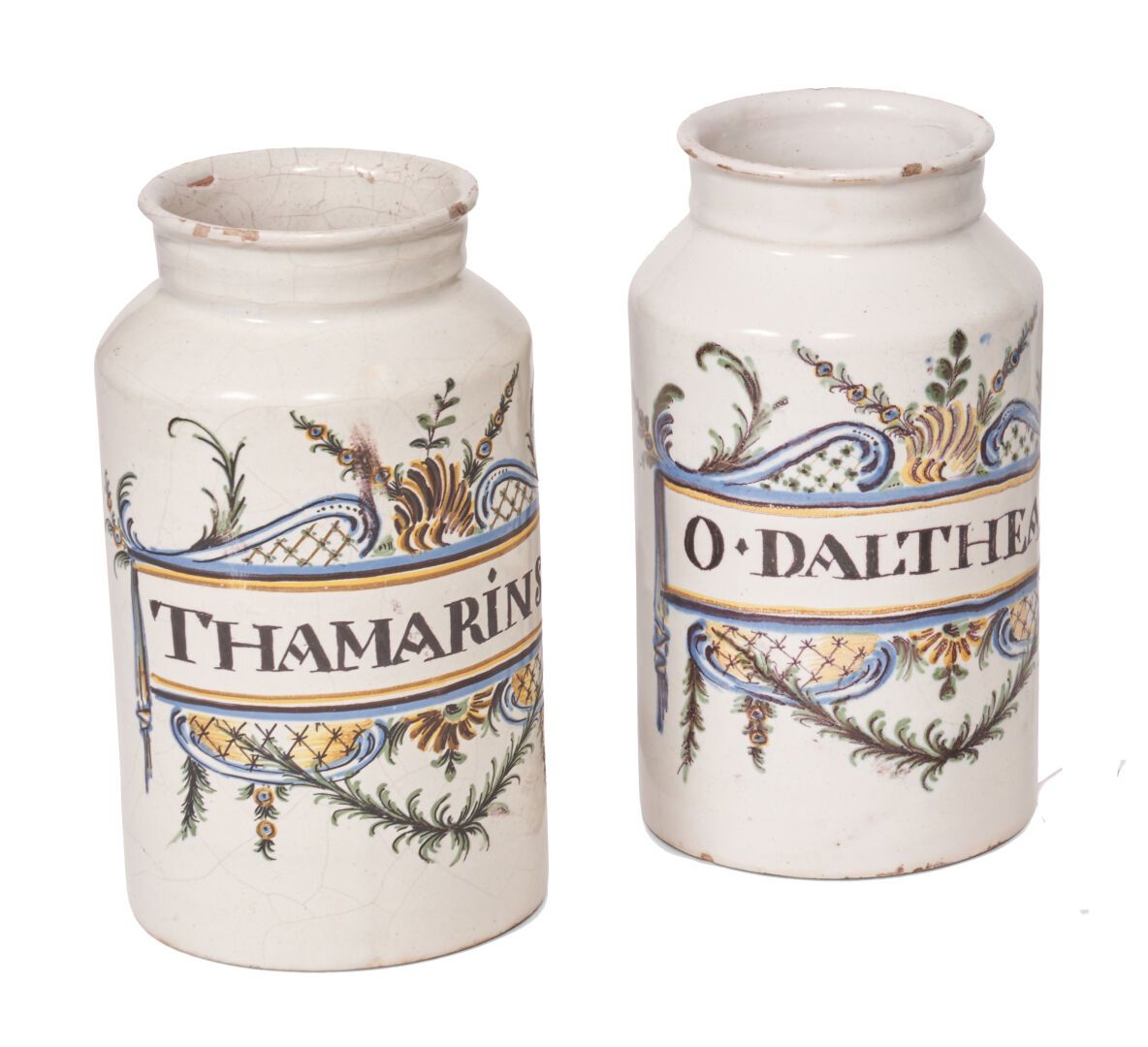 Null 中型
两个陶制圆柱形药罐，多色装饰的铭文THAMARINS和O DALTHEA，周围环绕着叶子和花架背景的叶子。
18世纪。 
H.21厘米。
小碎片&hellip;