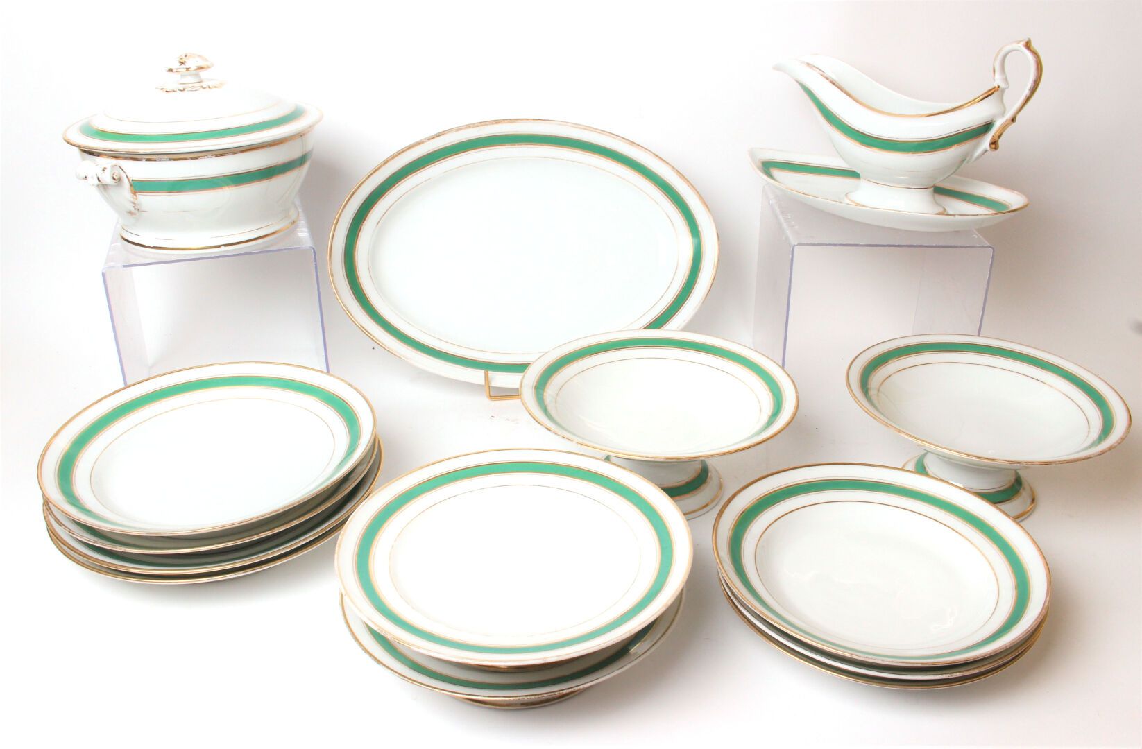 Null 利莫盖斯

绿色和金色网状装饰的瓷器服务套装，包括基座上的展示架，十二个汤盘和两个餐盘。

(筹码)