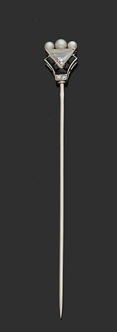 Null 铂金85万分之一的领带针，末端在三颗文化小珍珠和玛瑙图案之间装饰着一颗三角形的钻石。
1930年左右的法国作品。
高度：7厘米
毛重 : 1,8 g