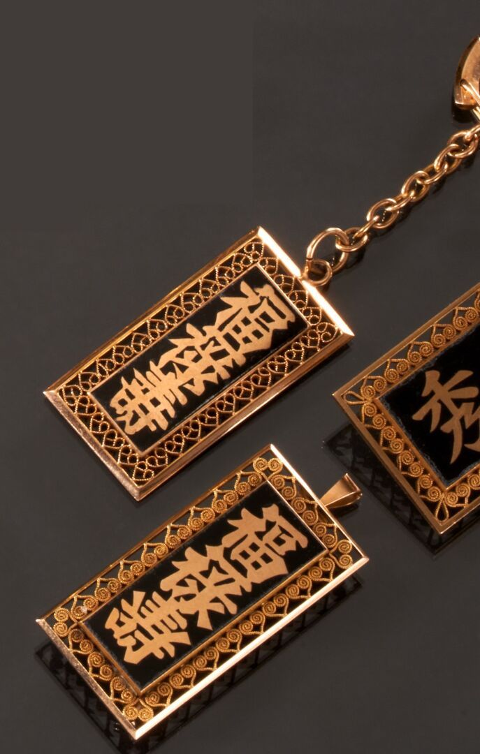 Null 750千分之一的黄金拍品，装饰有玛瑙或黑色珐琅的亚洲文字，包括两个胸针，一个形成吊坠和一个钥匙圈。
(有划痕)
重量 : 39,5 g