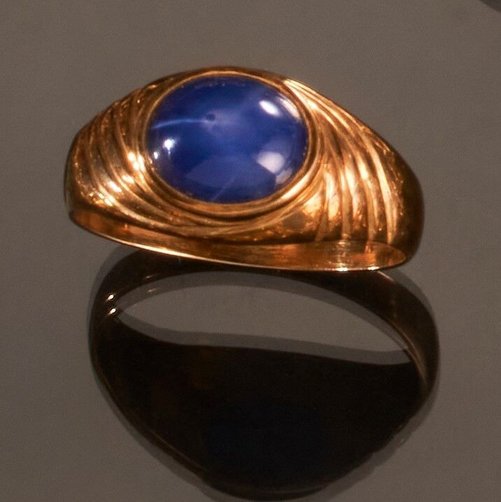 Null 千分之七十五的黄金戒指，中心装饰有凸圆形的蓝色合成宝石。
指轮：61 
毛重：4.6克