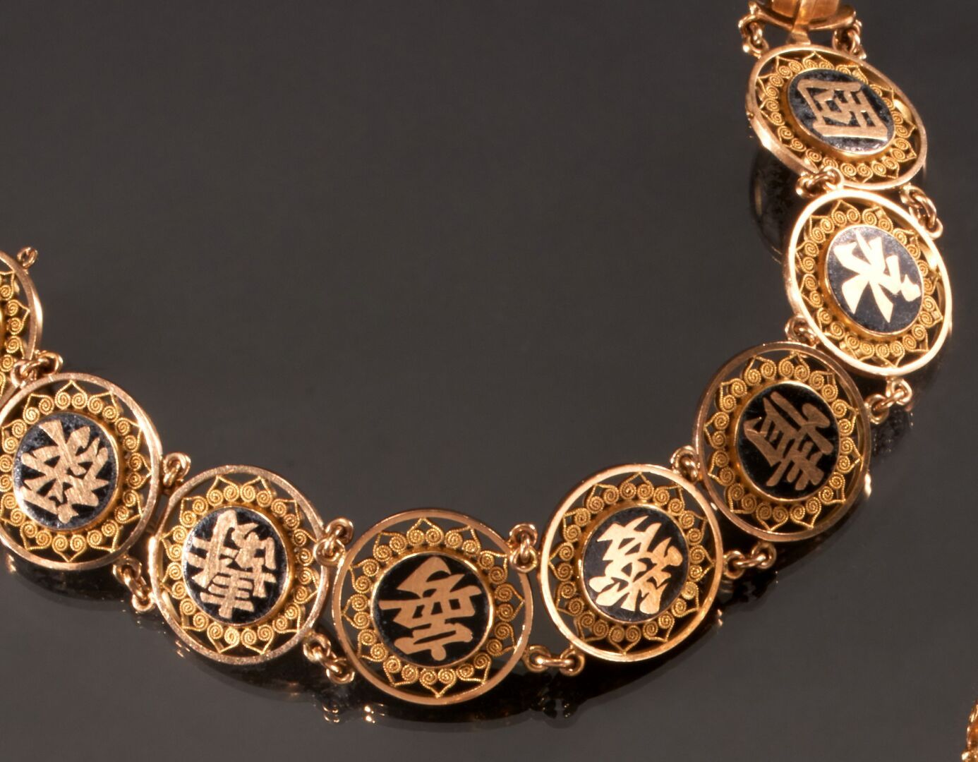 Null 75万分之一的黄金铰链手镯，链节上装饰有黑玛瑙板和亚洲文字。
(有划痕和缺失)
毛重：42.2克