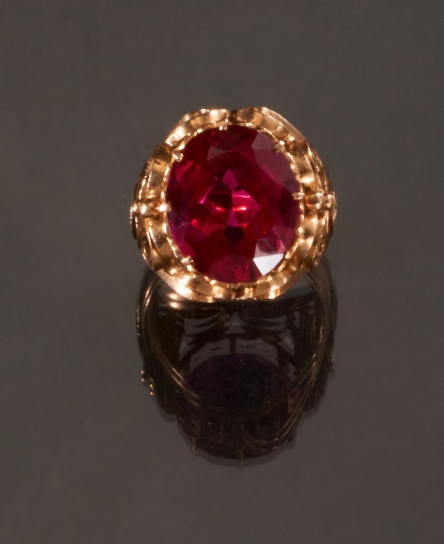 Null 千分之七十五的黄金戒指，中央饰有红色仿石。
(佩戴)
手指尺寸 : 56 
毛重 : 10,1 g