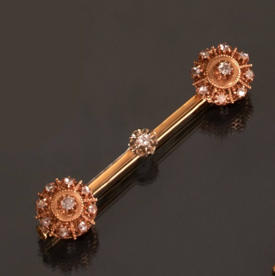 Null 黄金750千分之一的胸针，圆形的两端装饰有粉红色或旧尺寸的钻石。
(变形)
长度 : 5 cm
毛重 : 5,2 克