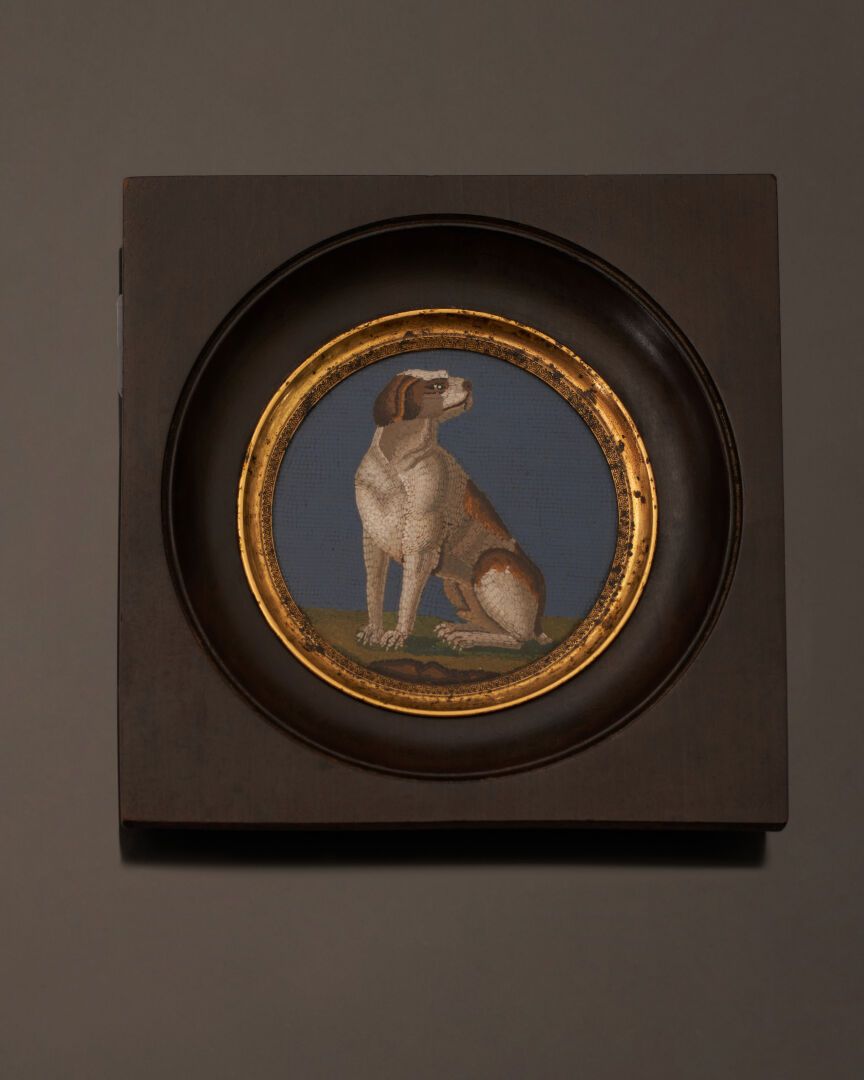 Null 一幅圆形的微型马赛克，展示了一只坐在蓝色背景上的狗。装在一个发黑的木框里，镀金的金属框上有棕榈花纹的楣。
19世纪。
直径：6,7厘米
框架：13 x&hellip;