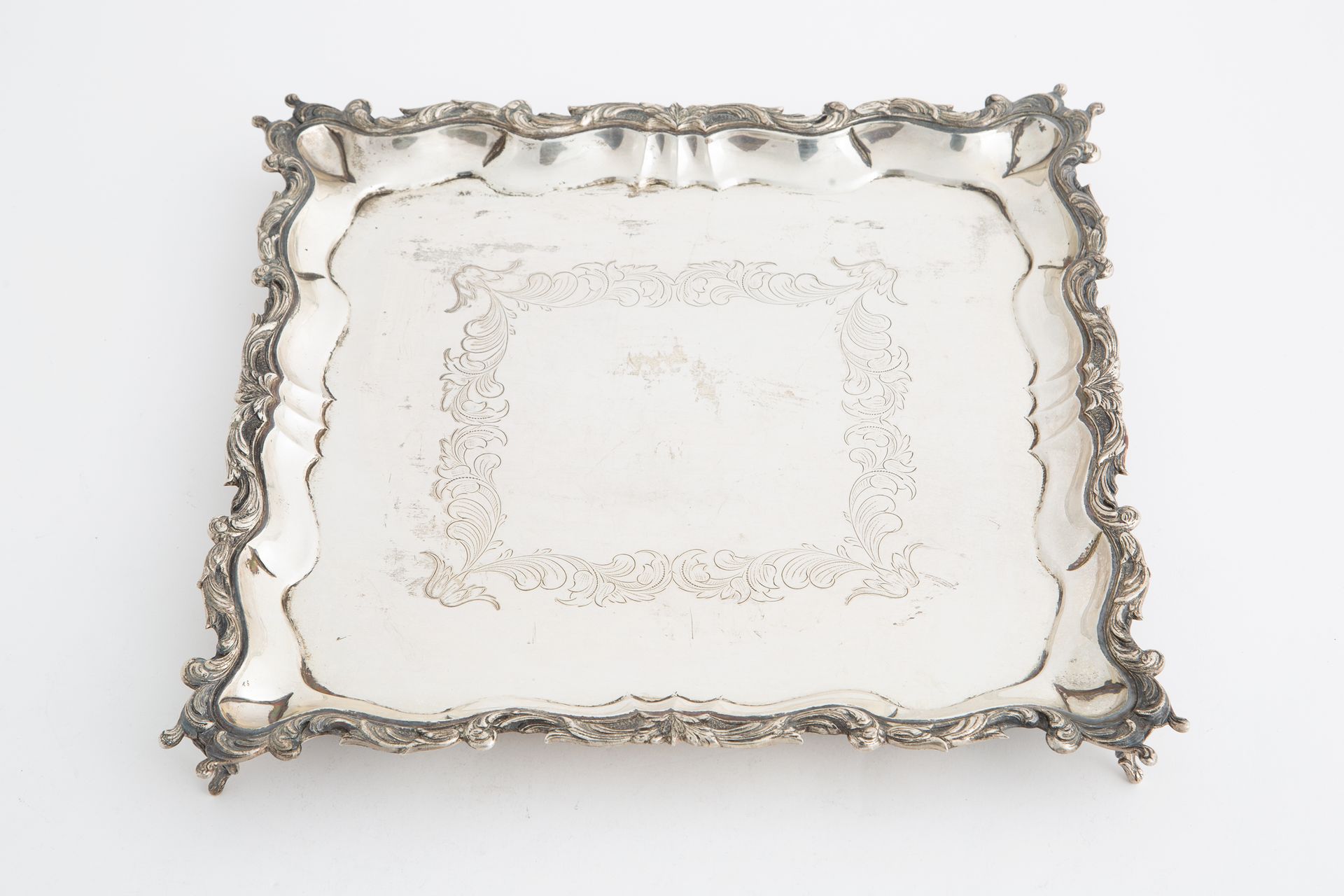 Silver tray, gr. 1050 ca. Early 20th c. Plateau carré avec pieds en argent cisel&hellip;