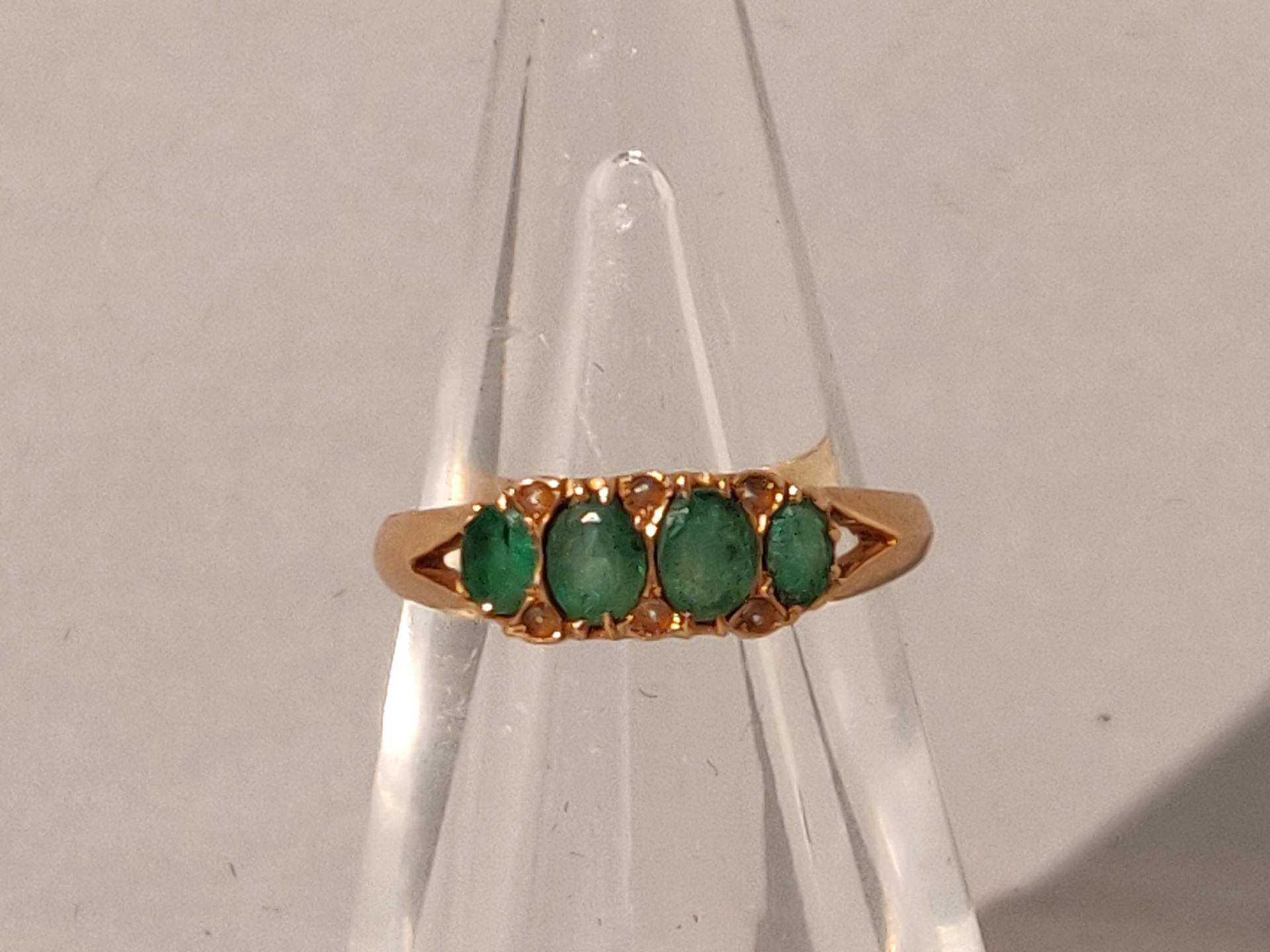 Null 
黄金戒指（750/°°），镶嵌有四颗绿宝石（碎片）。毛重：1.8克。TDD : 55.