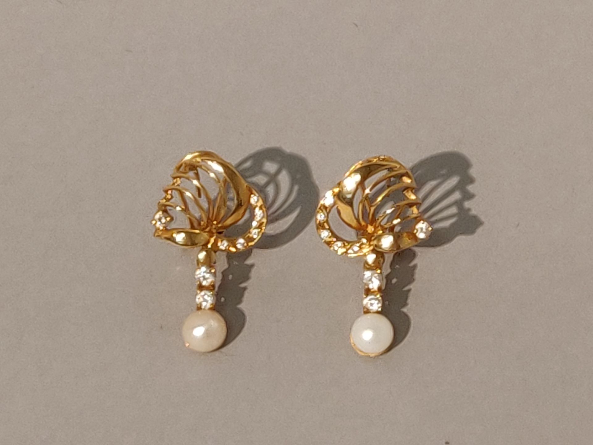 Null 镶嵌白色宝石和珍珠的一对黄金耳环。长2.5厘米，毛重：7克。国外工作。