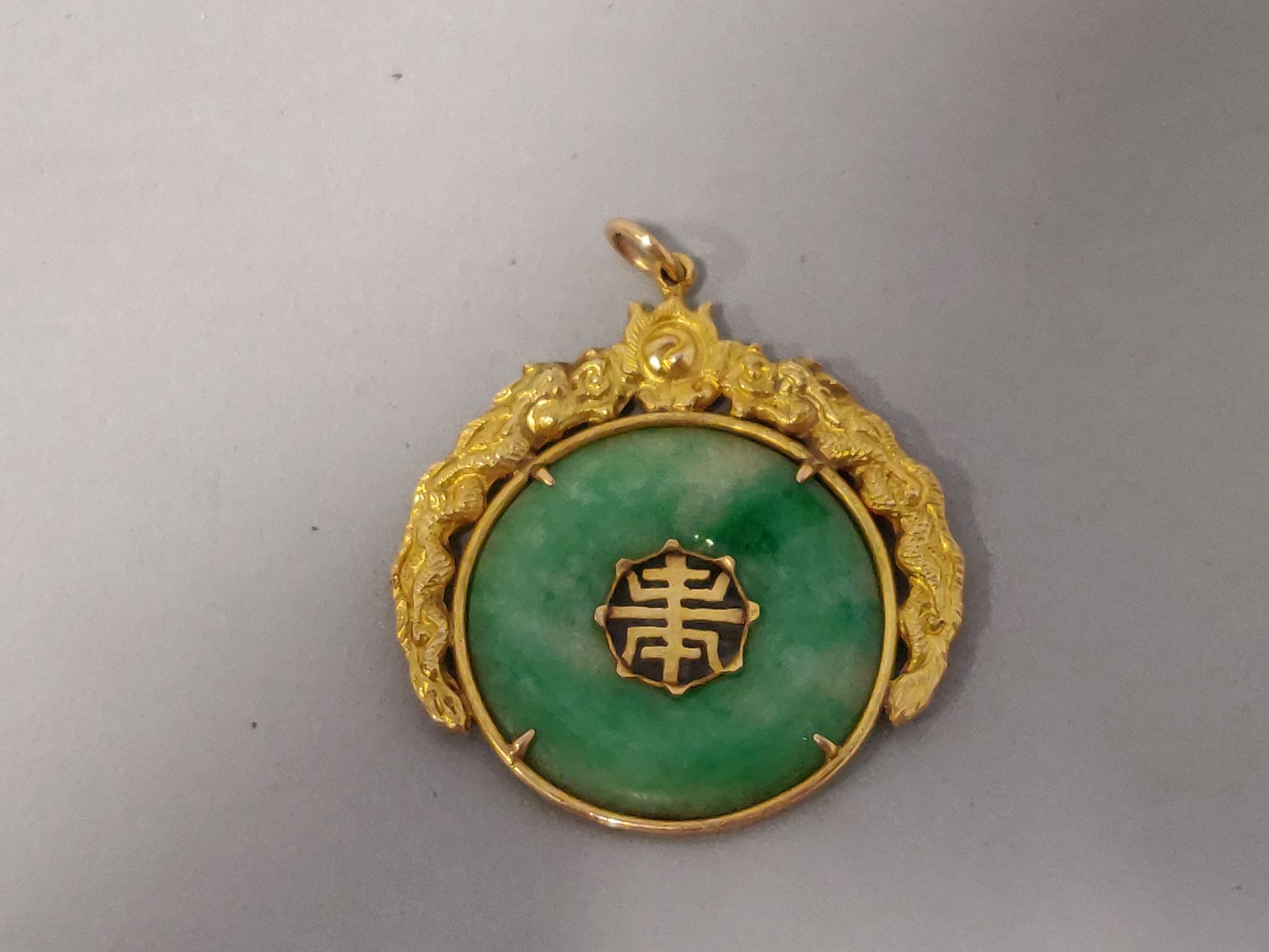 Null 
A jade disc pendant with an ideogram in a 9k yellow gold setting. Foreign &hellip;
