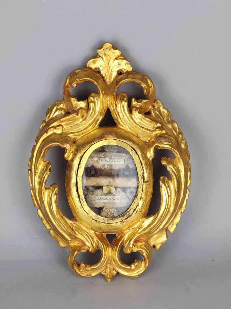 Null CADRE RELIQUAIRE de forme ovale en bois sculpté doré et ajouré à décor d'en&hellip;