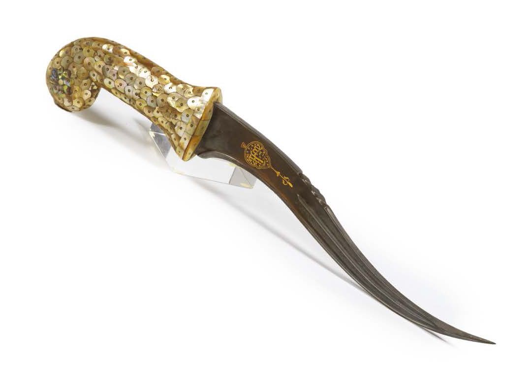 Null KHANJAR.正弦形的钢制刀刃上有金色的大马士革装饰的书法图样。手柄上装饰有珍珠母镶嵌板，形成鳞片，符合18世纪产品的风格。这种形式的把手多为玉质。&hellip;