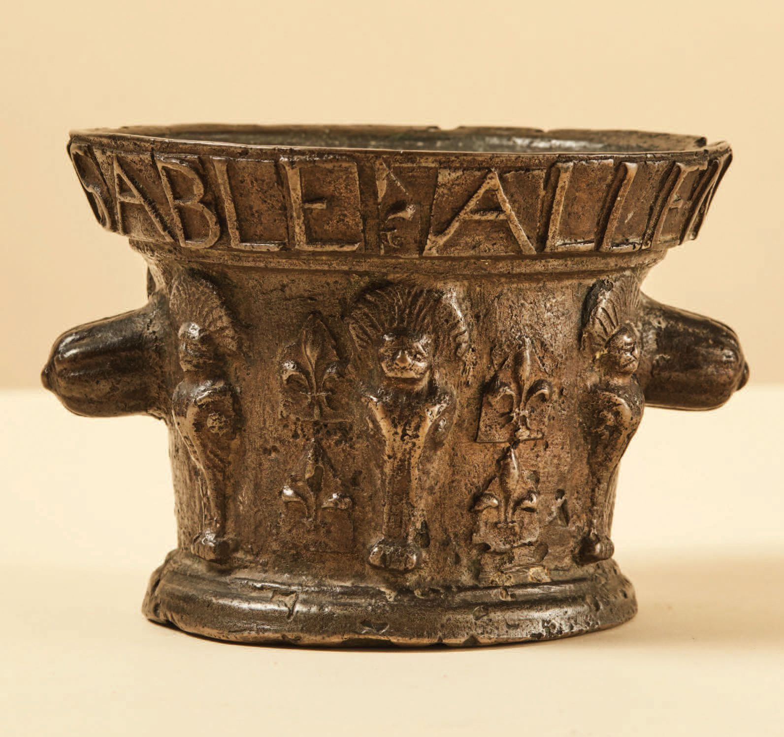Null Mörser aus Bronze mit Federkopfschmuck und Lilien; Rand mit der Inschrift *&hellip;