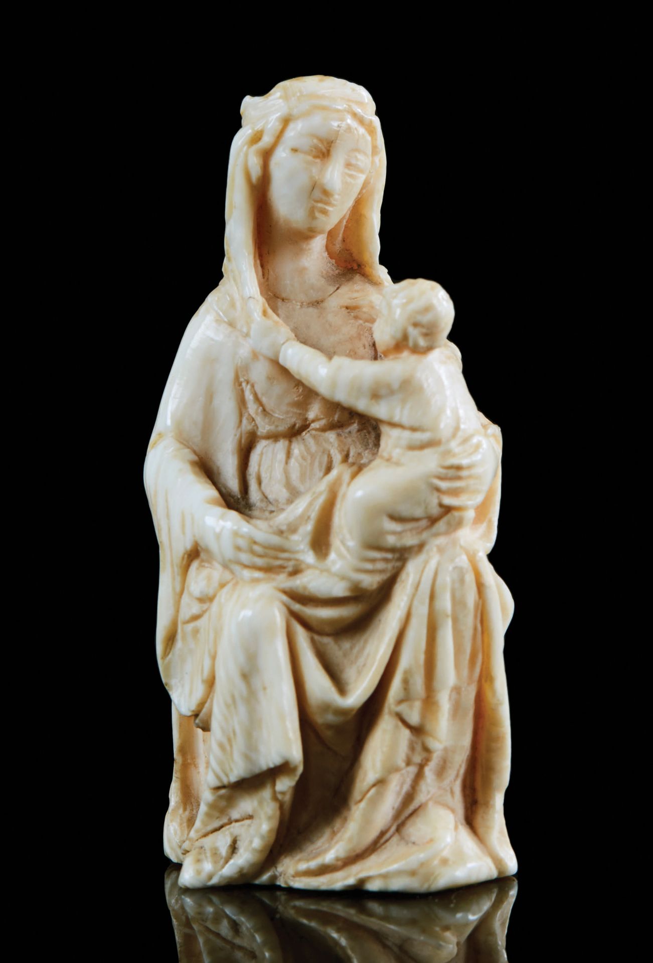 Null 象牙圆雕的小圣母和小童。她坐在一个模制的宝座上，用膝盖抱着她的儿子；在一个温柔的姿态下，他一手拿着他母亲的一部分面纱，另一只手放在她的肩膀上；玛丽穿着&hellip;