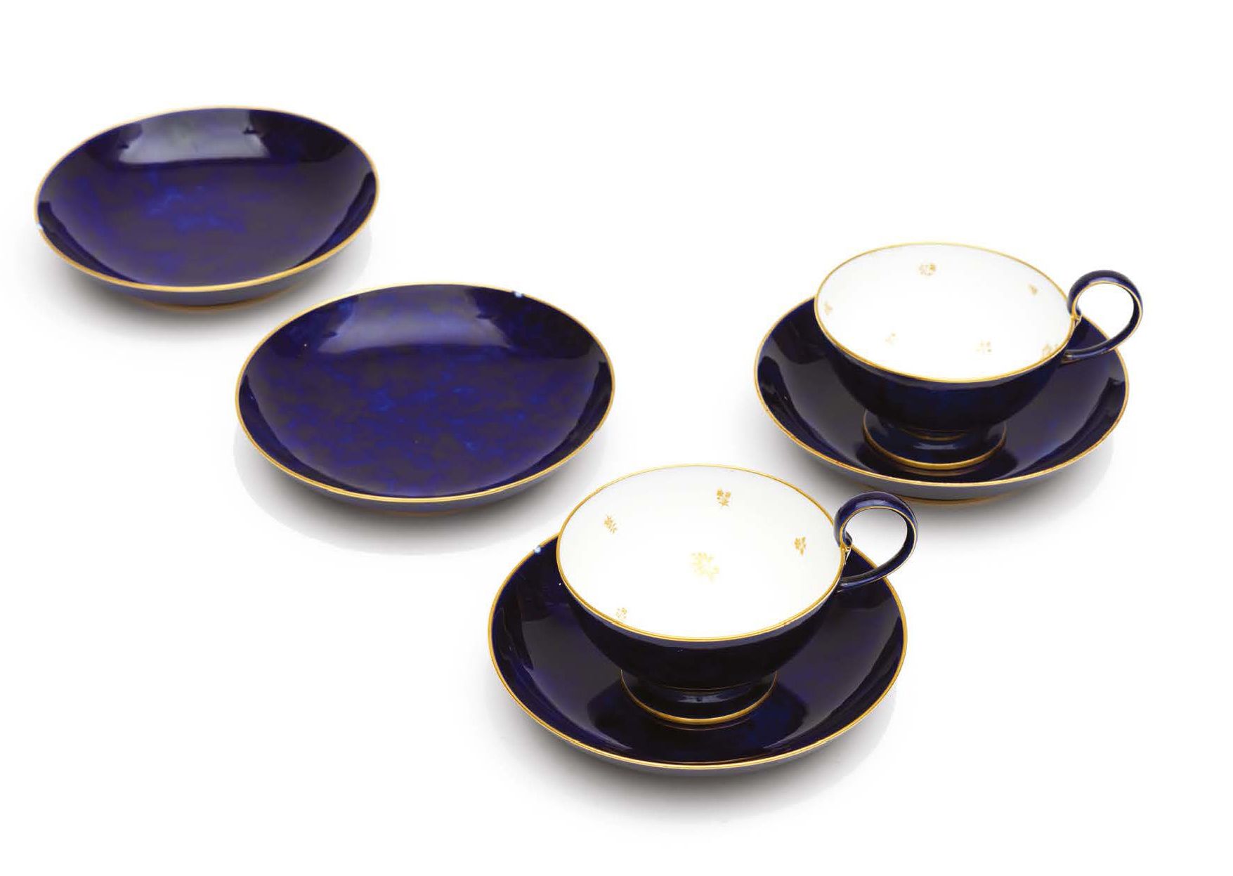 SÈVRES 一套2个杯状的杯子和4个碟子的瓷器，有美丽的蓝色背景和阴影装饰，杯子上有字母图案。
塞夫勒国家制造厂，20世纪。
H_7 cm D_17.5 cm
