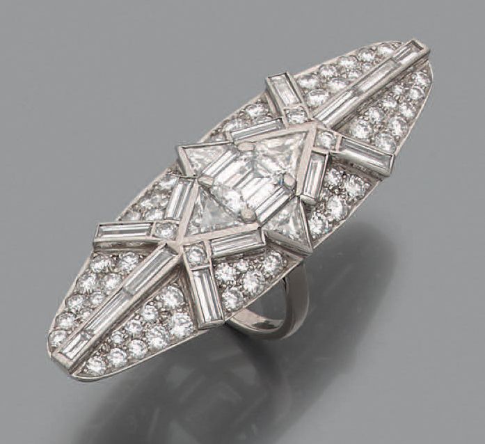 Null 铂金和18K(750)白金榄尖形戒指，铺设明亮式切割钻石，镶嵌在长方形切割钻石矩阵中，中心是一颗祖母绿切割钻石(重约1克拉)，周围是四颗特洛伊钻石。
&hellip;