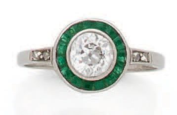 Null 18K(750)白金戒指，镶有一颗圆形老式切割钻石，重约0.7克拉，周围有校准的祖母绿。
，是20世纪20年代的法国作品。
TDD : 52
毛重 :&hellip;