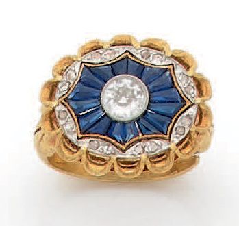 Null 
铂金和18K(750)黄金戒指，椭圆形的铂金表圈中心是一颗老式切割的钻石，周围是校准的蓝宝石，表圈上镶嵌着玫瑰花。



1900年代的作品，带有现&hellip;