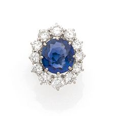 Null 重要的18K(750)白金雏菊戒指，爪式镶嵌一颗枕形蓝宝石，周围有明亮式切割钻石。
蓝宝石的重量：约6.80克拉。
它附有日期为2022年4月5日的巴&hellip;