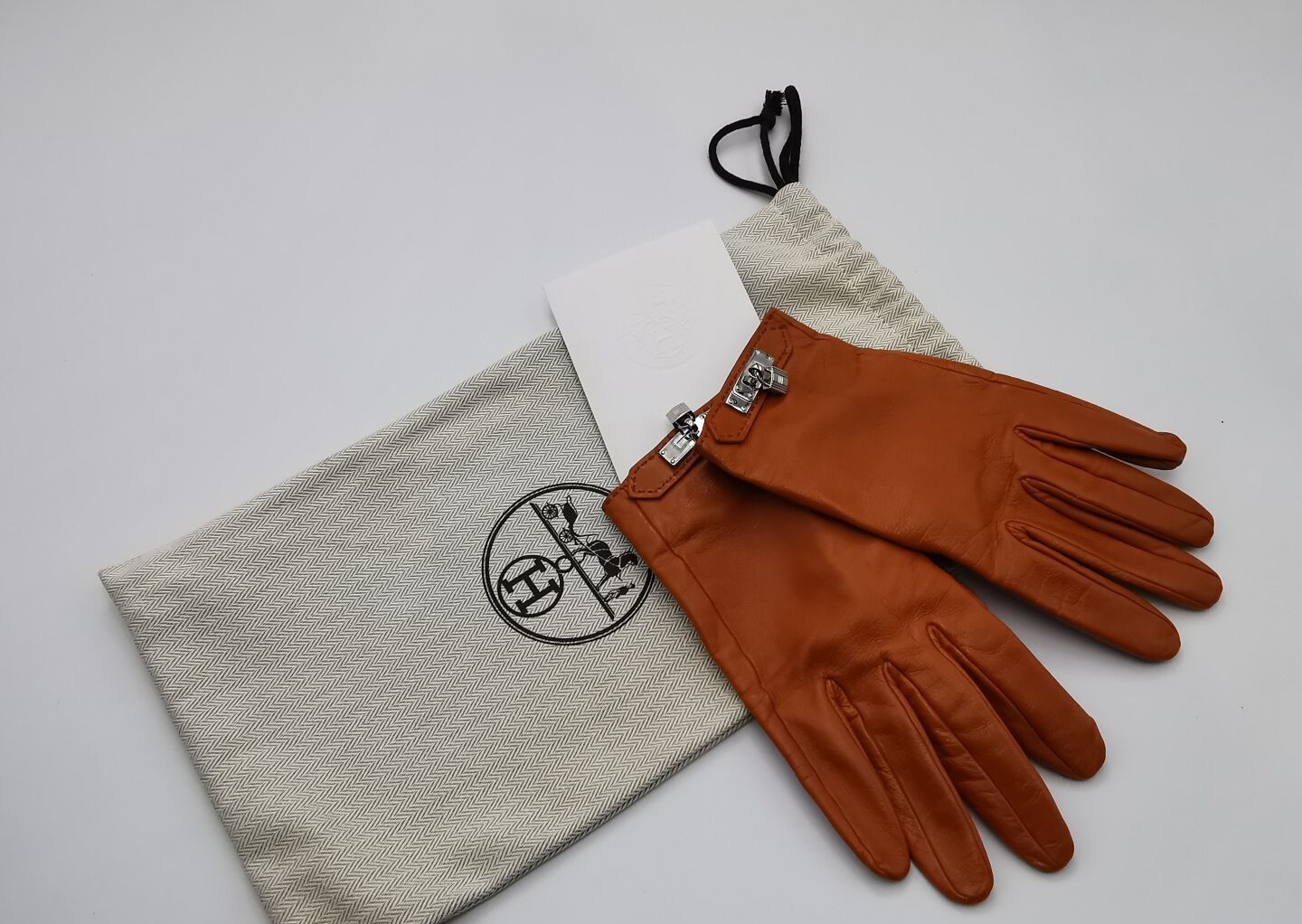 Null 赫米斯
一双SOYA型号的手套，橙色绒毛小羊皮，钯色凯利珠宝，丝绸衬里。
尺寸：7.5。
爱马仕的清洁发票和小袋。