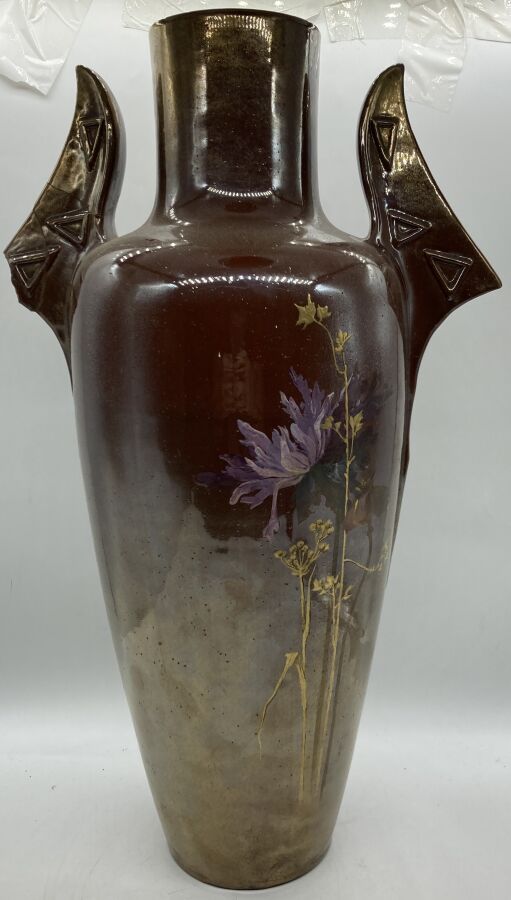 Null 克莱蒙-马西埃(1844-1917)

一个大的陶瓷花瓶，身体呈卵形，颈部呈管状，有两个完整的侧向把手（事故和修复）。茄子色背景上有多色和金色珐琅彩的&hellip;