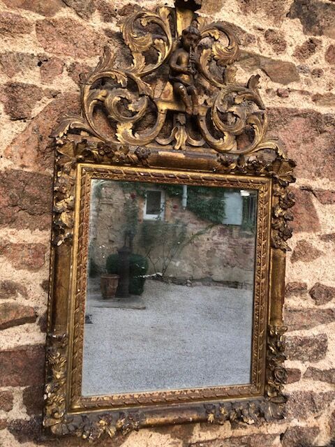 Null 一面镜子，镜框上雕刻着雏菊和玫瑰花，镜座上雕刻着叶子交错围绕着一个音乐天使。

18世纪。

H.124厘米 - 宽73厘米。

事故，修复。后来泰恩&hellip;