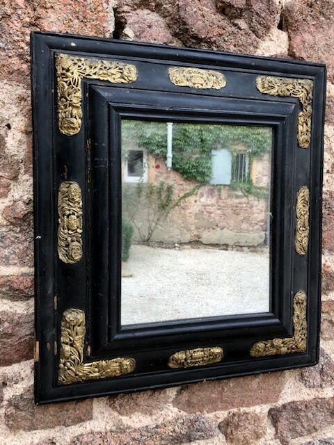 Null 一面发黑的木质镜子，有倒立的轮廓，有模子的框架，有浮雕的黄铜和花的装饰。

17世纪。

57 x 52 厘米。

事故、修复、缺失的零件。