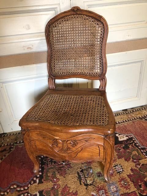 Null 一把雕花的榉木藤椅。

18世纪。

H.91 cm - W. 48 cm - D. 43 cm。

事故，以前的油漆。