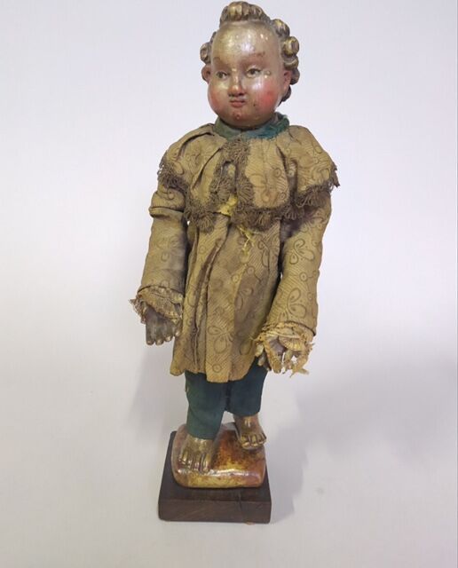 Null 多色雕刻的木制儿童，胖乎乎的脸，卷曲的头发，穿着他的衣服。

18世纪。

H. 42厘米，不含底座。

木质底座。

事故。