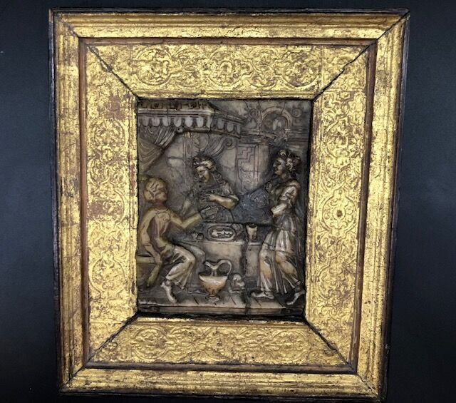 Null 梅赫伦。一块雕刻的雪花石膏牌匾，以前是镀金的，代表三个女人在天幕下围着一张桌子，一只狗在她们脚边。

用雕刻和镀金的木头装裱。

17世纪。

盘子：&hellip;