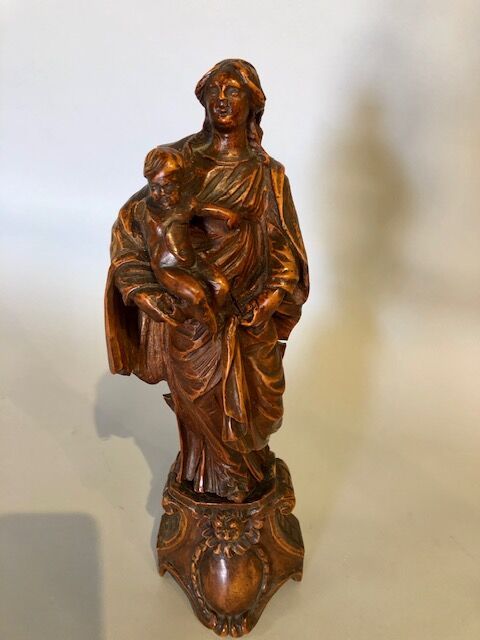 Null 蜡制木质（黄杨木？）的圣母，右臂抱着孩子，呈现在一个装饰有天使头像的底座上。

18世纪。

总高度：29厘米。

事故和零件丢失。