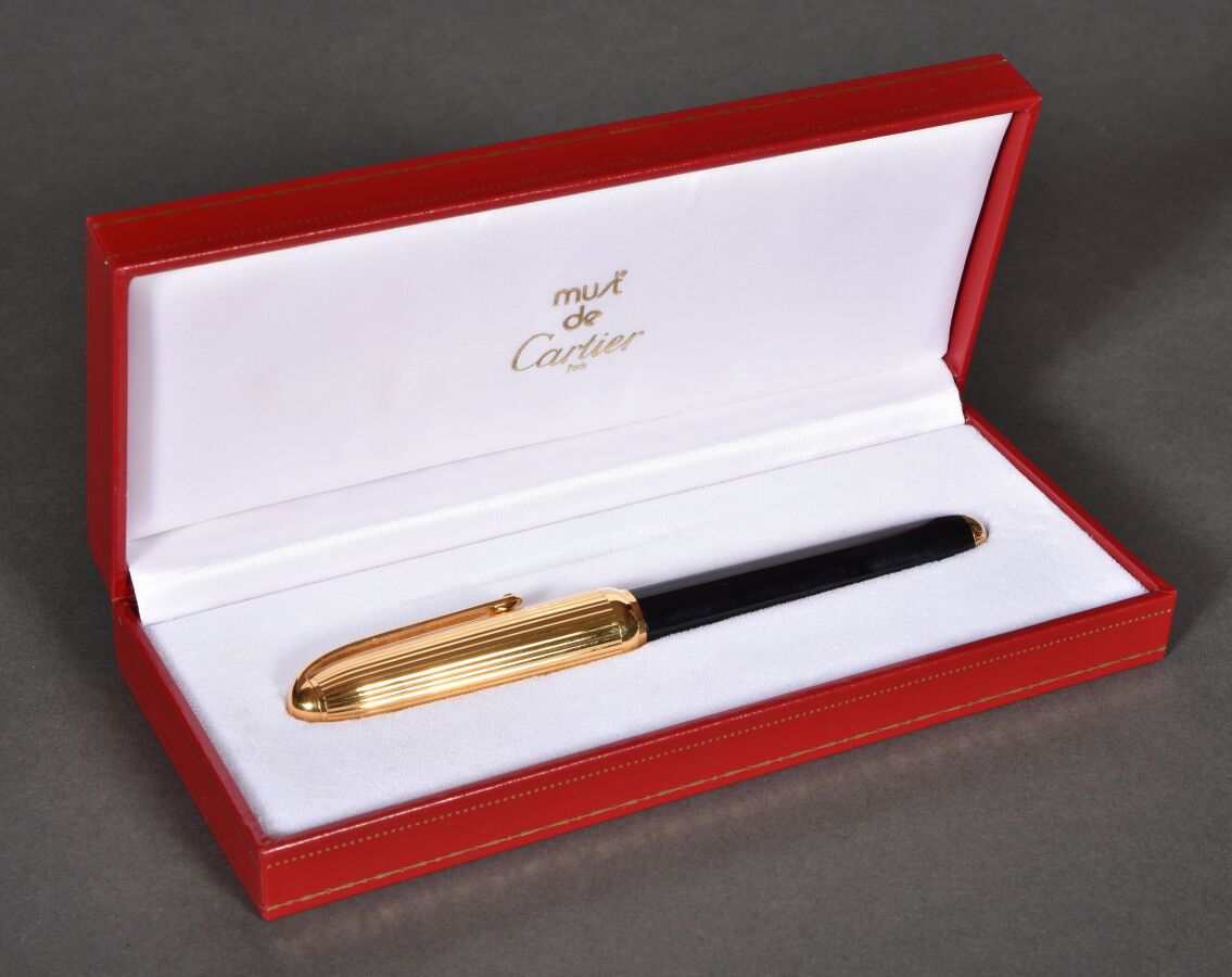 Null CARTIER. Stylo plume Pasha métal doré godronné et laque noir, plume 18k. Da&hellip;