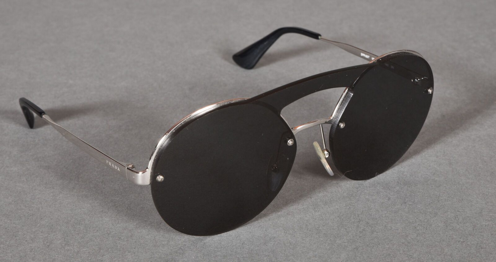 Null PRADA。一副镀铬金属的太阳镜和圆形黑色塑料眼镜。在他们的情况下。