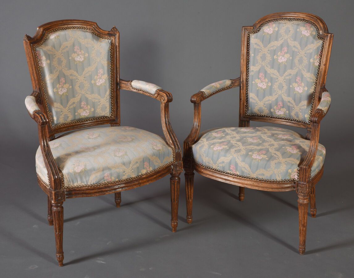 Null 两把山毛榉扶手椅，带铜锈，模制和雕刻有花朵。在锥形的、有凹槽的和有鱼鳍的腿上。

18世纪。

H.90 cm - W. 58 cm D. 50 cm&hellip;