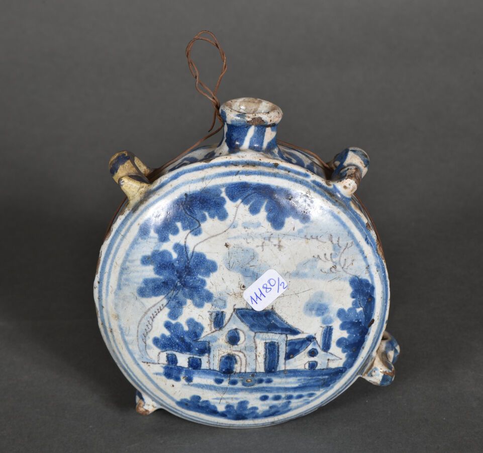 Null NEVERS或ROUEN。

扁平的圆形烧瓶，有四个环，表面有蓝色单色的装饰，下有锰，表面是有建筑的风景，另一面有1745年的日期。

18世纪。

&hellip;