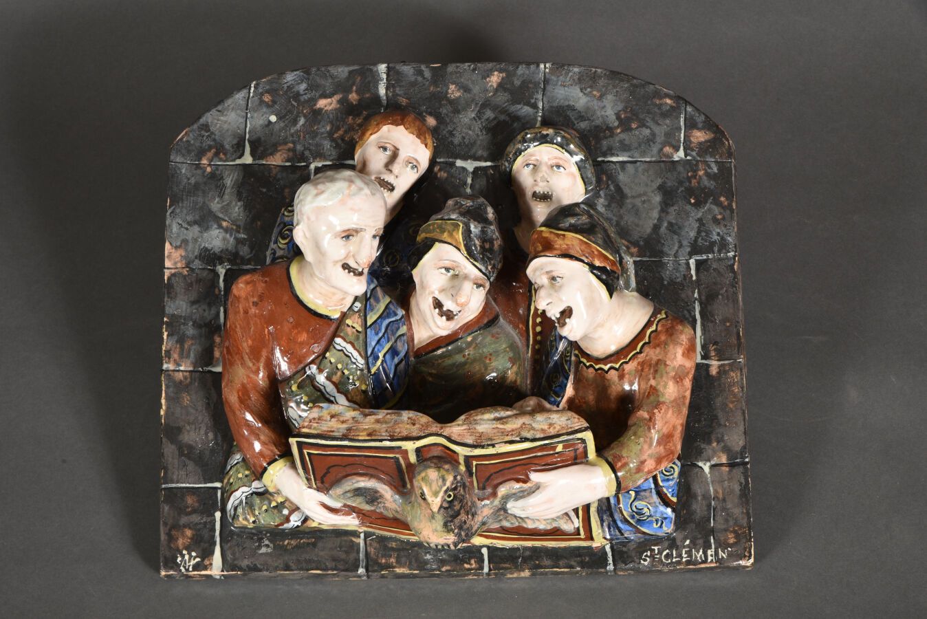 Null 多色陶器浮雕 "Les chantres "表现了五个人物，他们张着嘴咨询一本音乐书。右下方刻有 "St Clémen "字样，左侧有字母图案。

1&hellip;