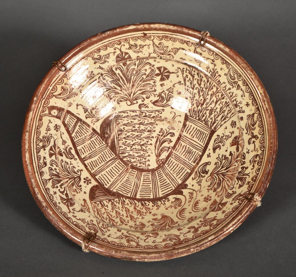 Null 西班牙。马尼塞斯。

大型伊斯帕诺-摩尔人陶器盘子，上面有金属光泽的 "pardalot "装饰，这是一只被花卉图案包围的大型梦幻鸟。

18世纪。
&hellip;