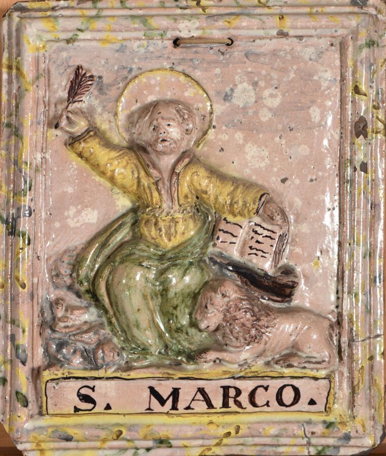 Null 意大利。

大的长方形陶器牌匾，在大理石背景上有圆形的多色装饰，代表圣马可右手拿着福音书和一根羽毛，一只狮子躺在他的脚下。铭文 "S.MARCO"。模&hellip;